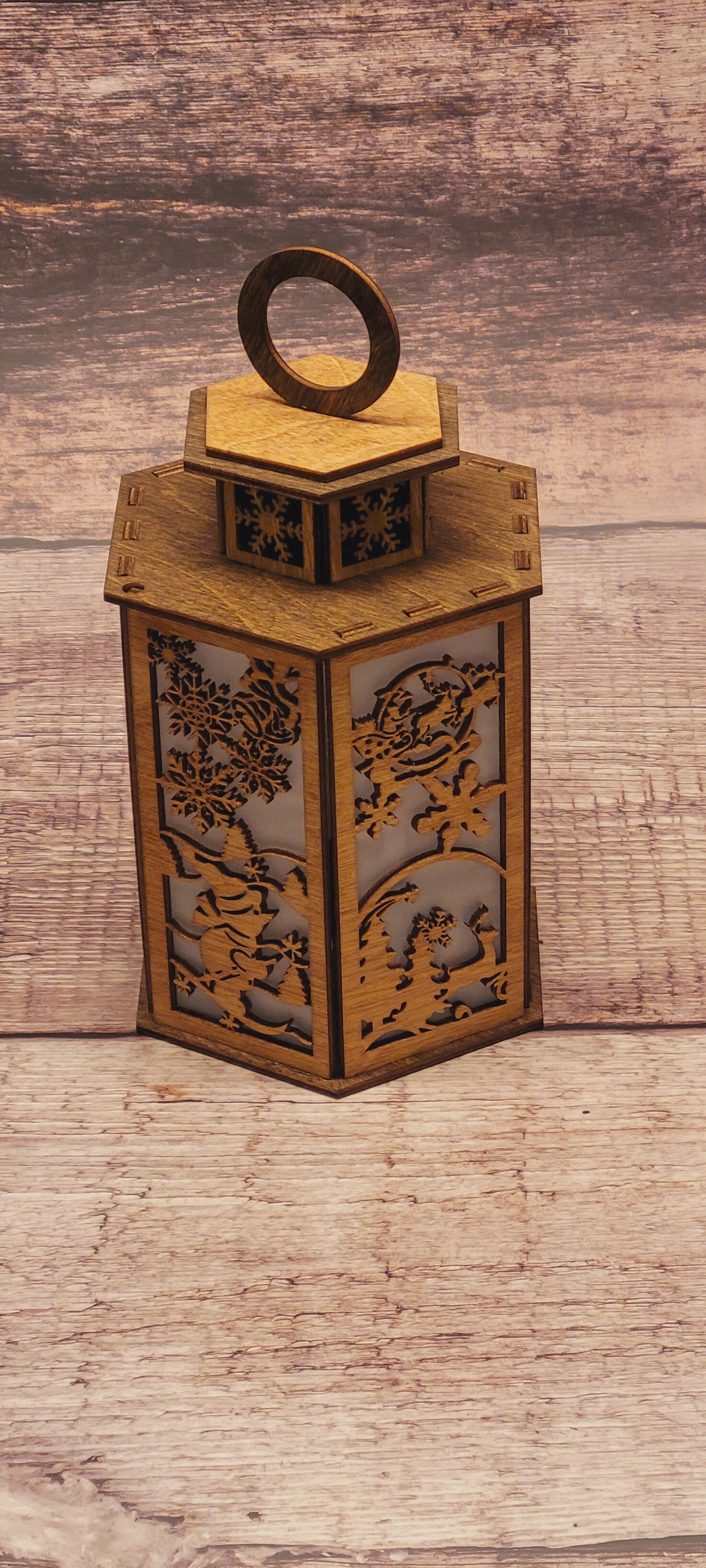 Close-up of tiered winter scene lantern highlighting precision laser-cut snowflakes and seasonal details