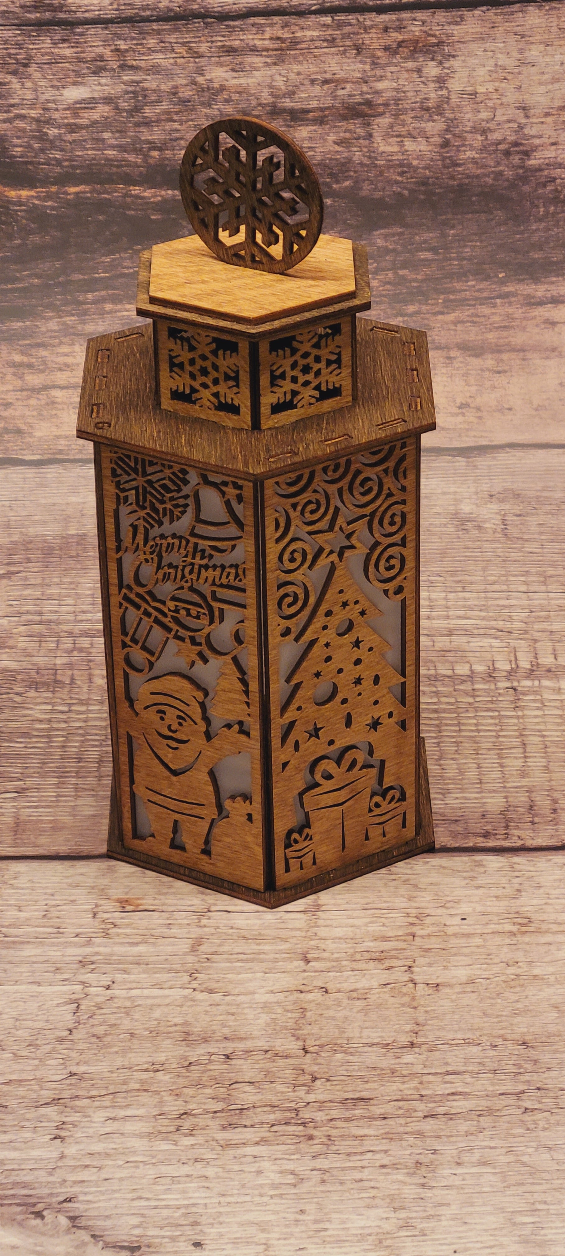 Handcrafted Christmas lantern in laser-cut wood with decorative snowflake handle and natural finish