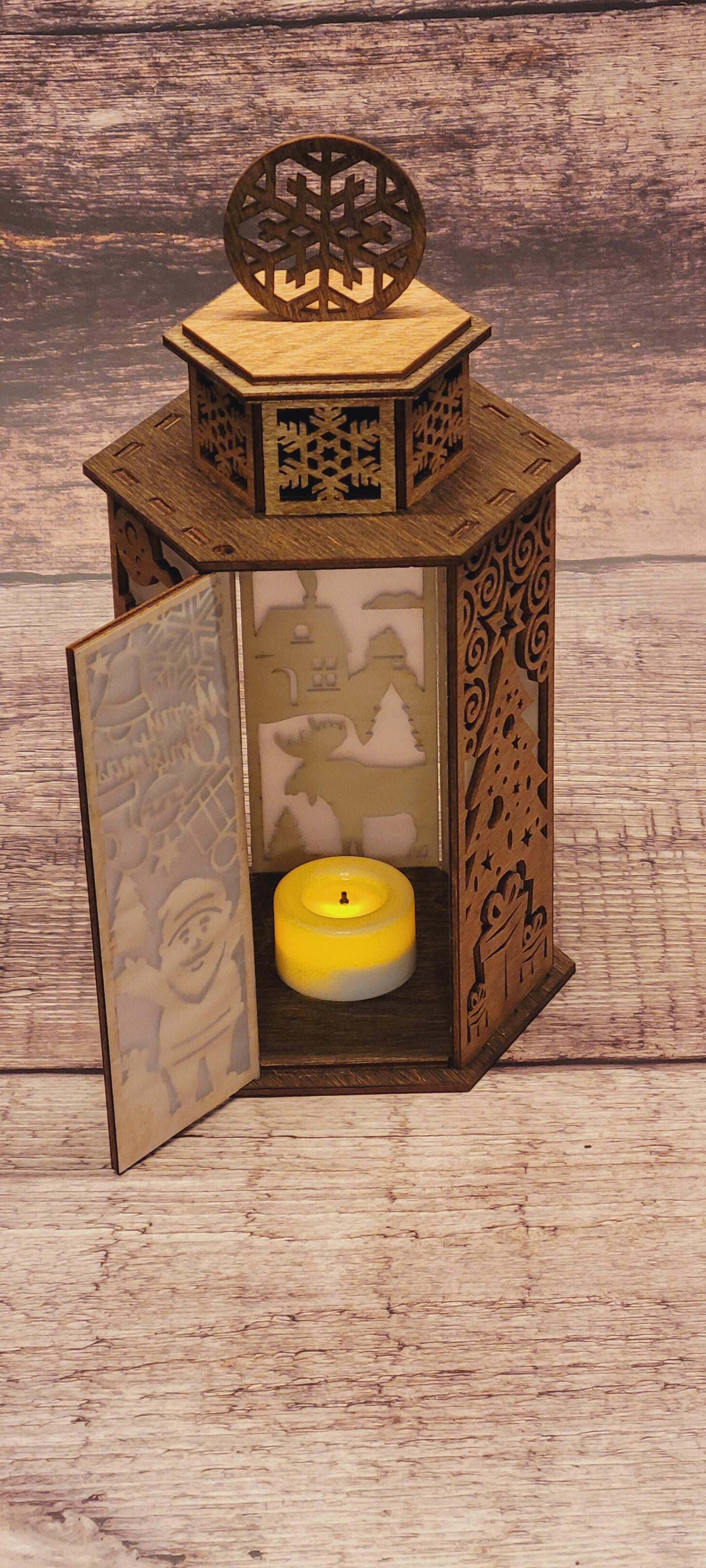 Side angle of handcrafted wood Christmas lantern with snowflake handle and candle holder opening