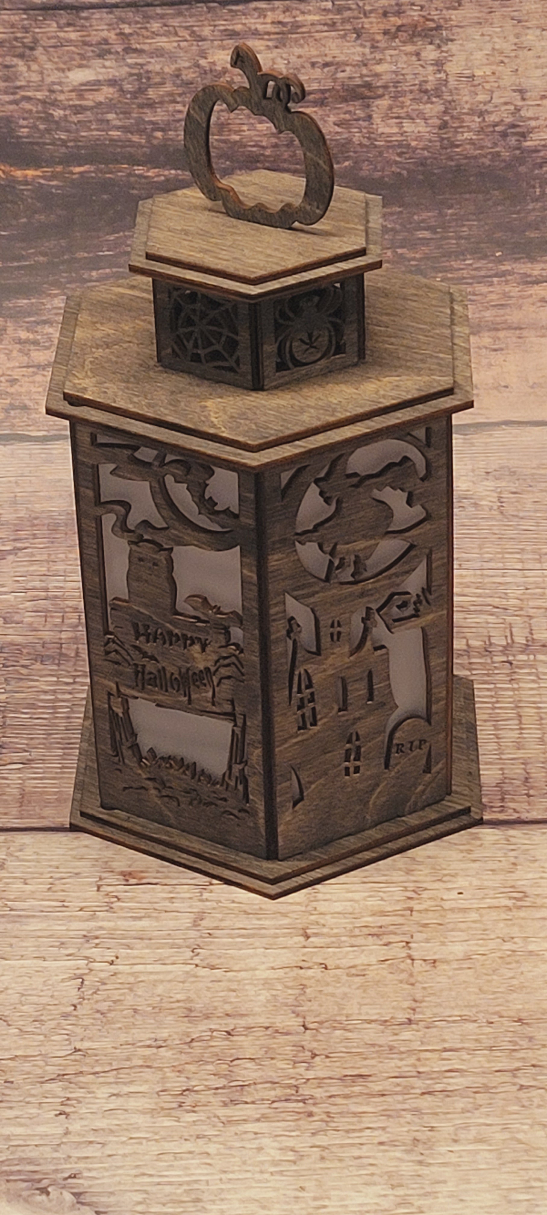 Front view of wood Halloween lantern featuring intricate pumpkin handle and spooky cutout design