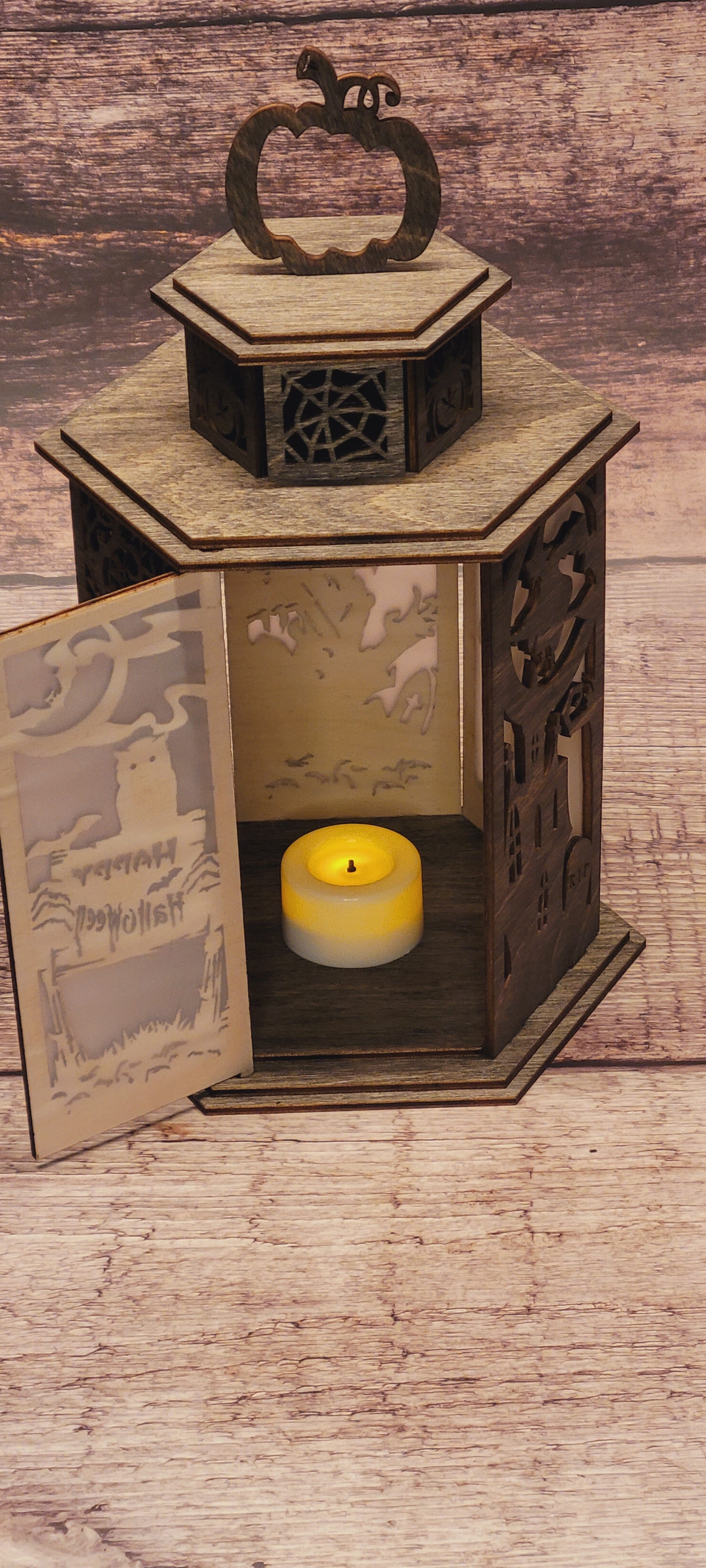 Side angle of handcrafted wood Halloween lantern with pumpkin handle and candle holder opening