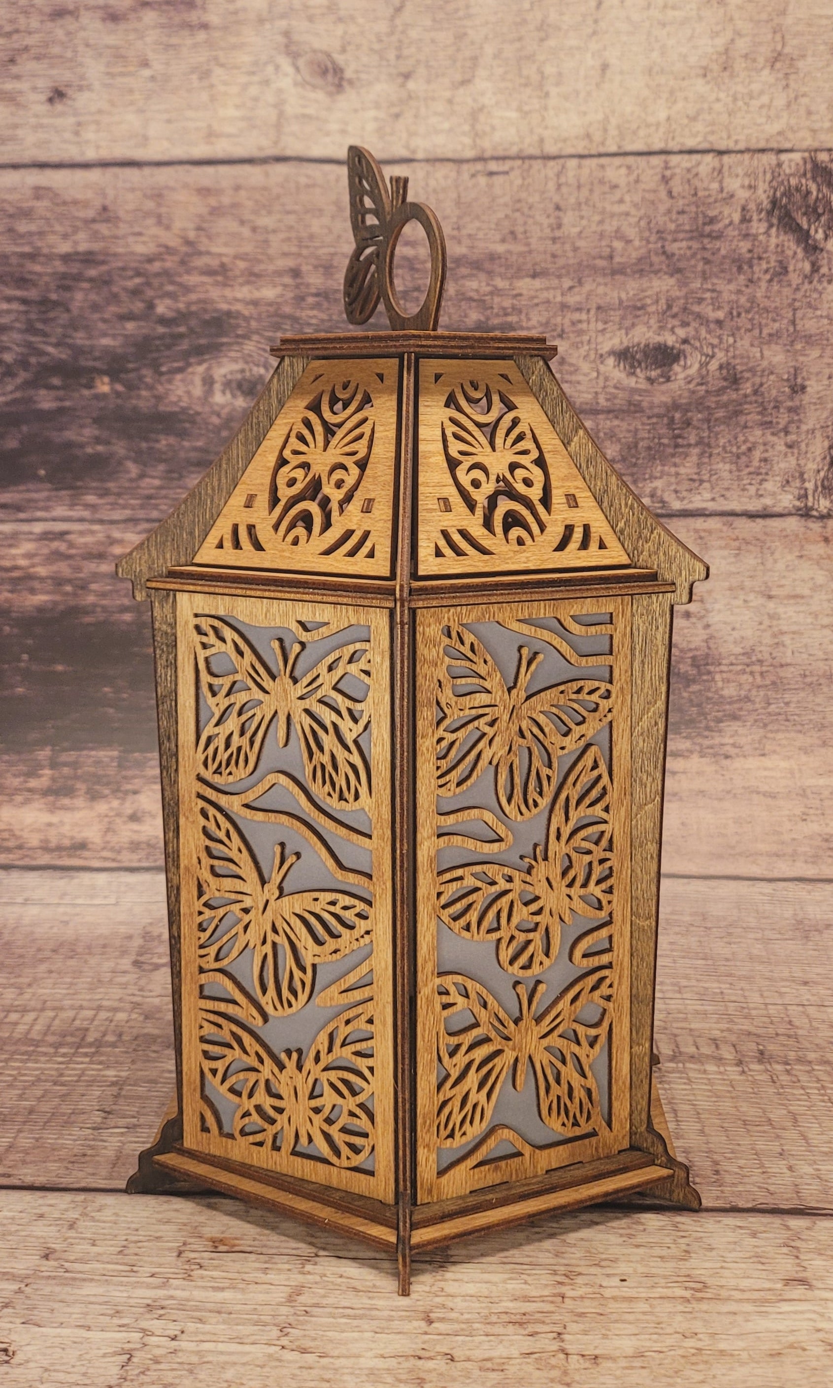 Close-up of butterfly lantern highlighting precision laser-cut wing details and wood craftsmanship