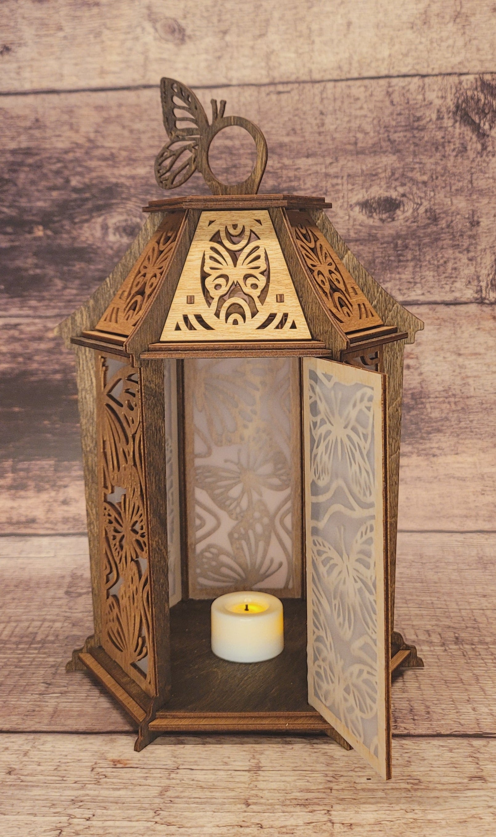 Side angle of handcrafted butterfly lantern showing three-dimensional structure and natural wood finish
