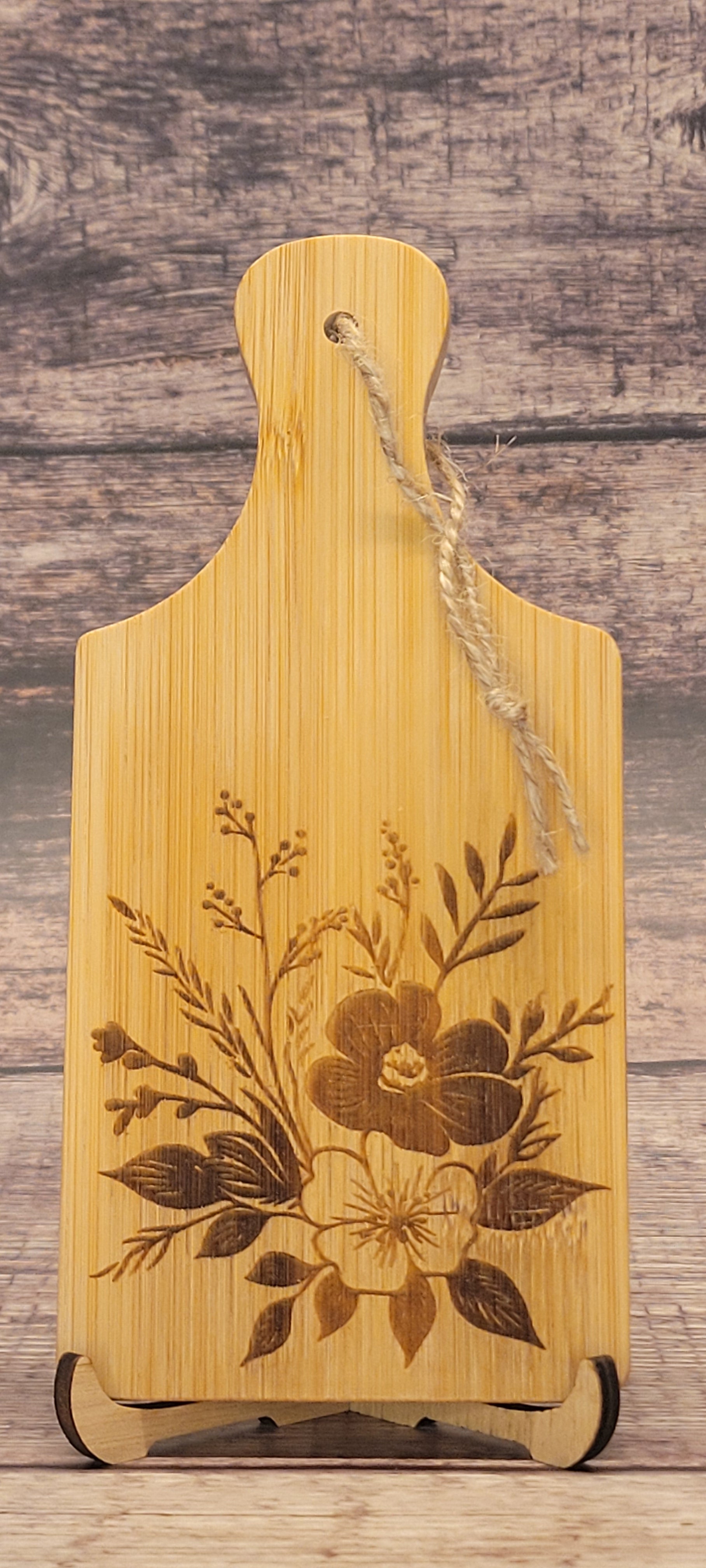 Bamboo charcuterie board with laser-engraved botanical floral design and natural grain