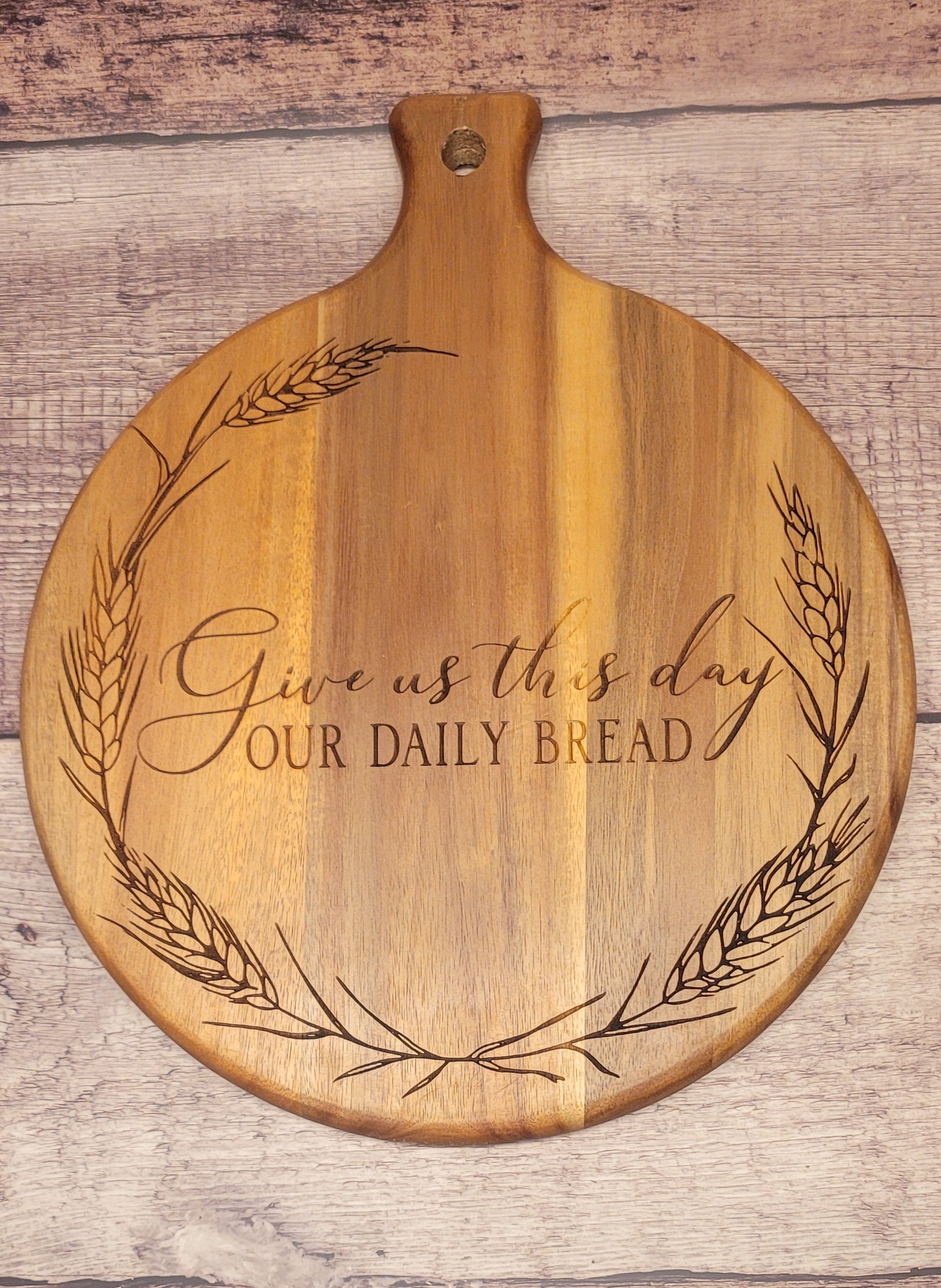Wood serving board with laser-engraved 'Give Us This Day Our Daily Bread' scripture
