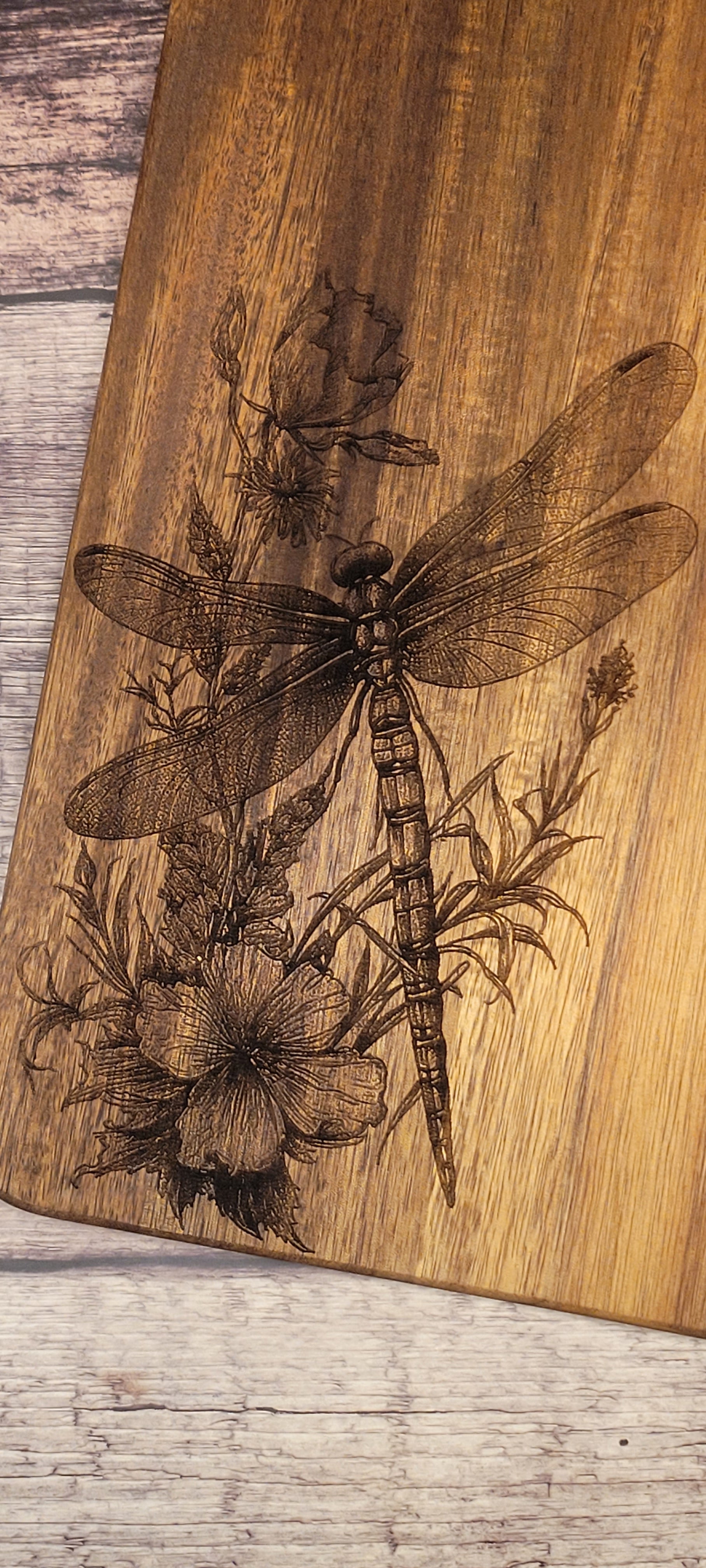 Close-up of dragonfly and wildflower charcuterie board showing engraving detail