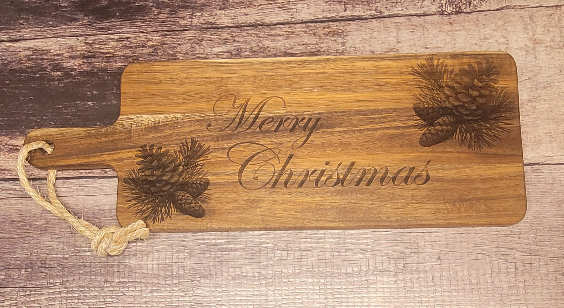 Front view of Christmas pinecone charcuterie board with holiday engraving