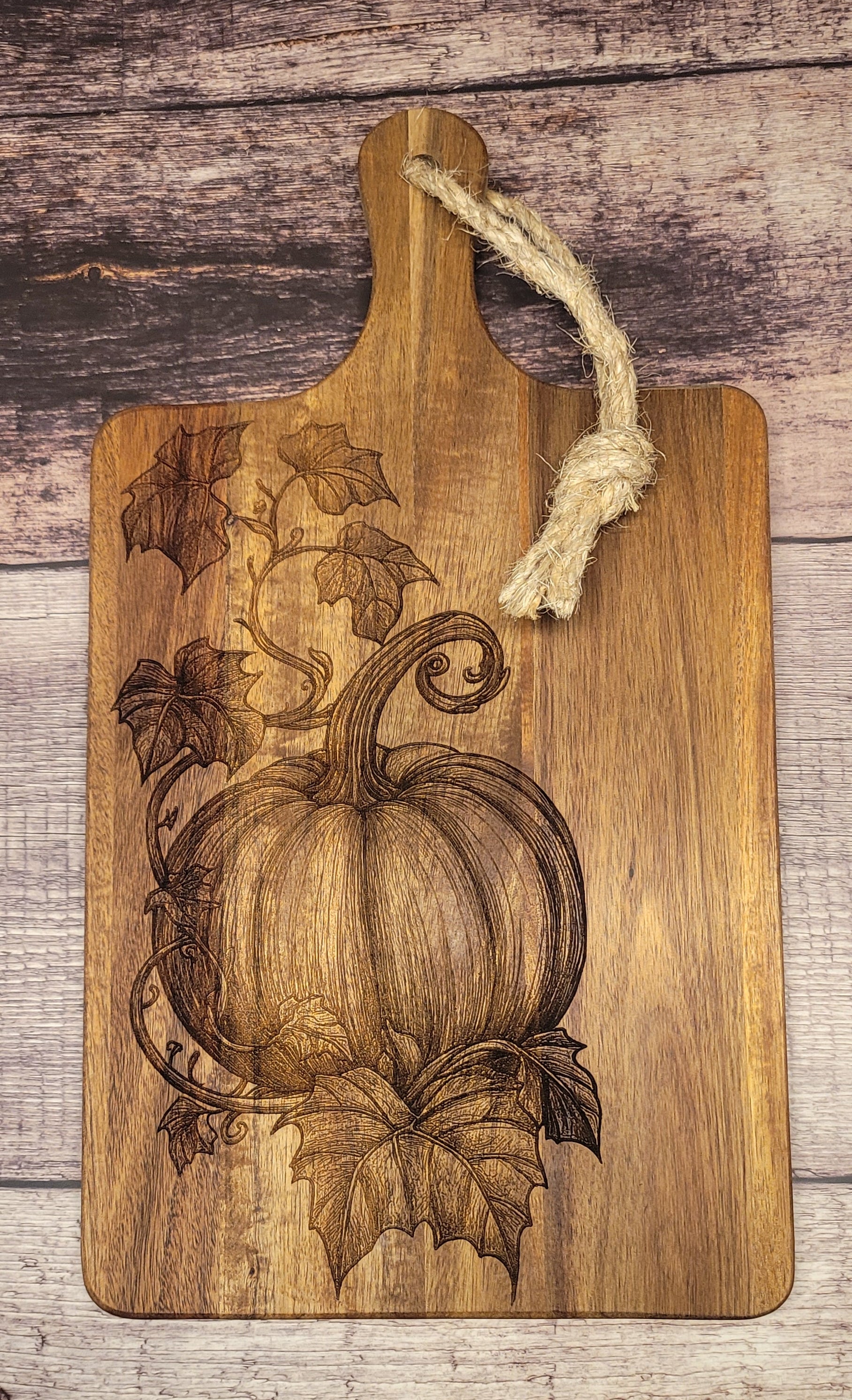 Wood serving board with laser-engraved harvest pumpkin and vine autumn design