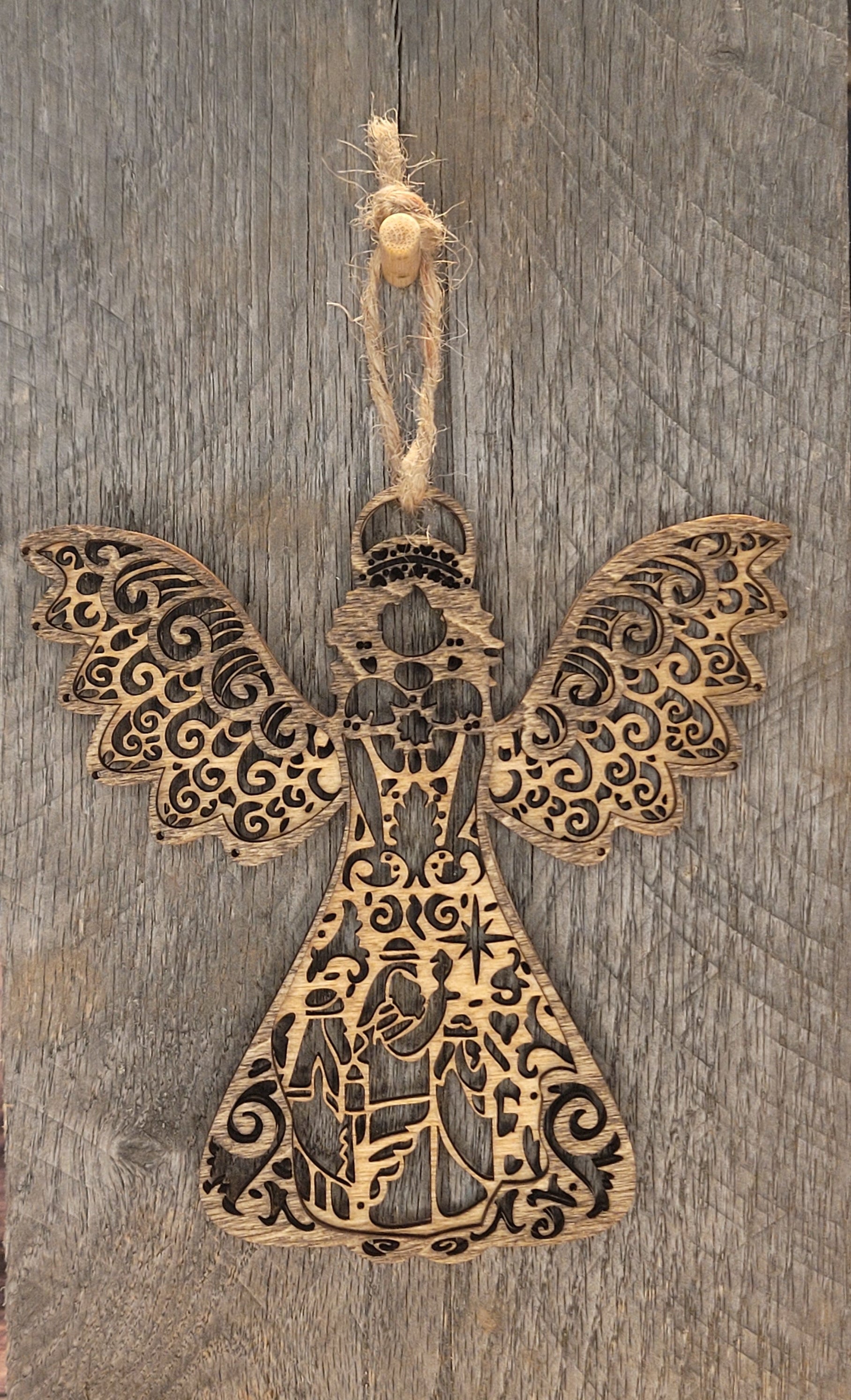 Two-tone wood angel ornament featuring laser-engraved nativity scene