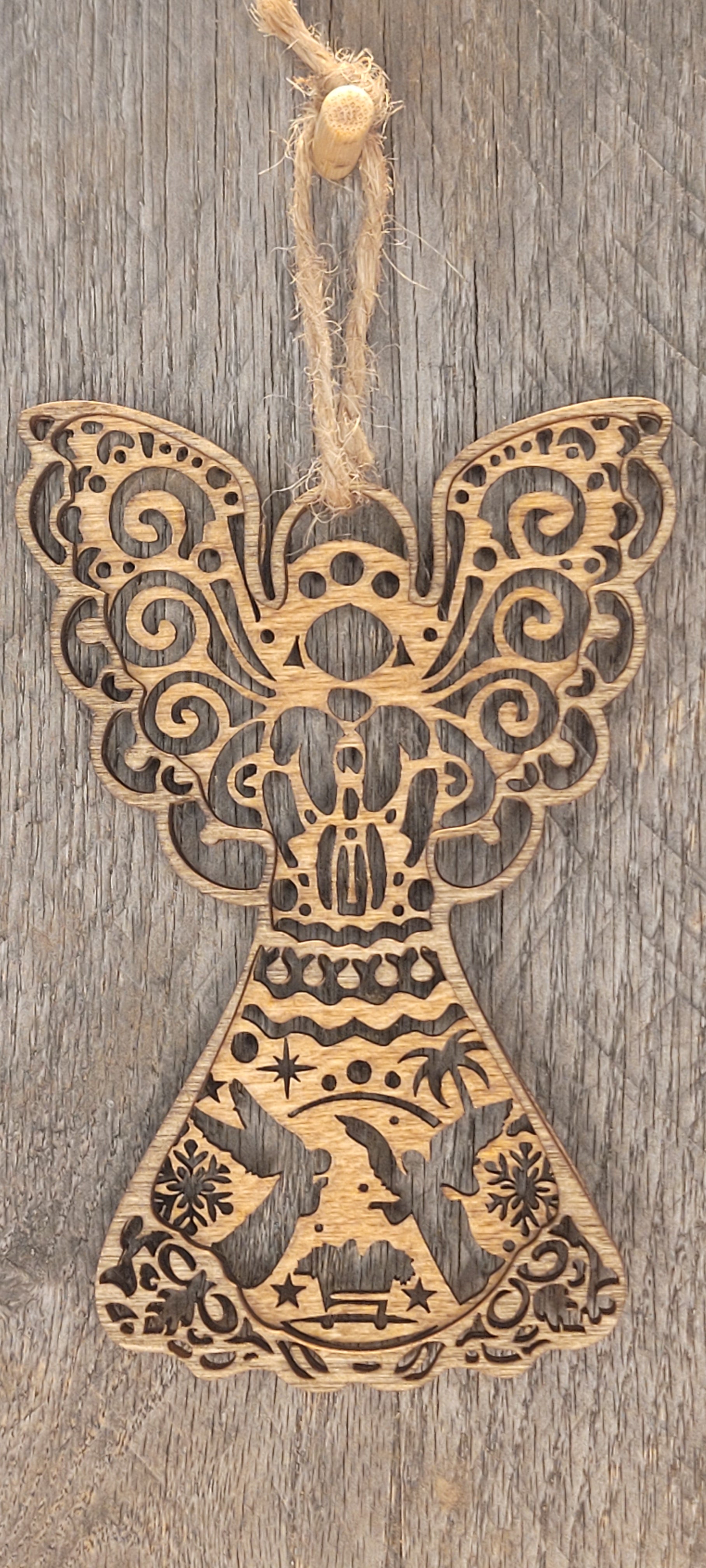 Two-tone laser-cut wood angel ornament with nativity scene detail