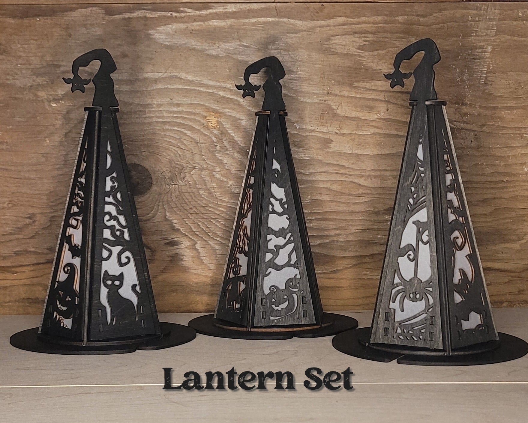Set of three handcrafted witches hat lanterns in black wood stain with Halloween-themed laser-cut details